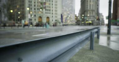 Urban street view with rain soaked pavement and guardrail in city video