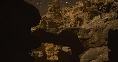 Unique rock formations illuminated by night sky in remote desert location video