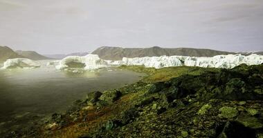 Glacial landscape with rocky shore and melting ice in wilderness setting video