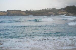 Serene Waves Crash on the Rocky Shore photo
