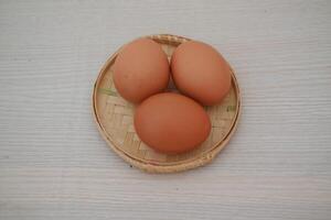 Fresh Brown Eggs on a Traditional Bamboo Basket photo