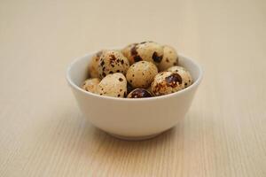Speckled Quail Eggs in a Simple White Bowl photo
