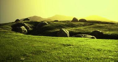 Rolling hills under a yellow sky with scattered rocks at sunset video