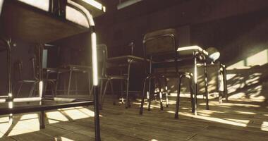 Empty classroom with sunlight illuminating desks and chairs in warm tones video