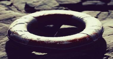Lifebuoy resting on rocky shoreline under soft sunlight in tranquil setting video