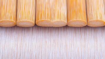 Close-up view of cut bamboo sticks arranged neatly on a smooth surface, showcasing texture photo