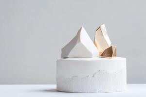 A striking minimalist cake features sharp, angular fondant textures and metallic geometric shapes. This elegant dessert is ideal for contemporary branding and modern festivities photo