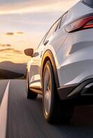 A stylish car glides smoothly on an open road as the golden sunlight washes over the landscape, creating an atmosphere of freedom and adventure in the early evening photo