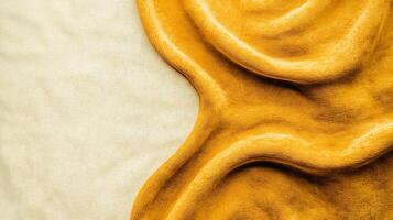 Close-up view of smooth, golden yellow texture resembling creamy substance on neutral background photo