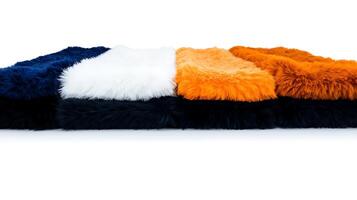 Colorful assortment of fluffy rugs arranged in a line against a white background, showcasing texture photo