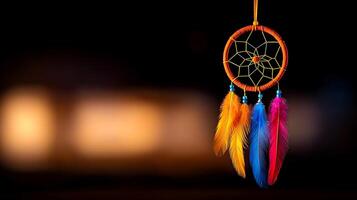 Colorful dreamcatcher with vibrant feathers hanging against a blurred dark background photo