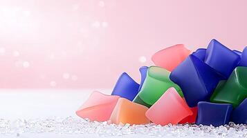Colorful gel cubes scattered on a soft surface with a blurred pink background, ideal for creative projects photo