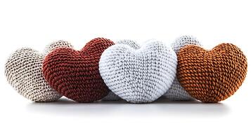 Colorful knitted hearts arranged in a row, showcasing texture and warmth against a white background photo
