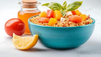 Colorful quinoa salad with fresh vegetables and basil, garnished with lemon and honey in background photo