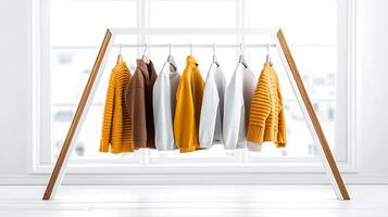 Colorful sweaters hanging on a modern rack in a bright, airy room with city views photo