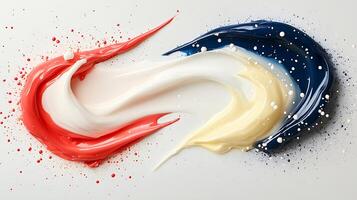 Colorful swirls of paint in red, white, blue, and yellow on a smooth surface, creating an artistic backdrop photo