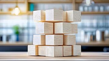 Stacked wooden blocks on a table in a bright kitchen setting with blurred background elements photo