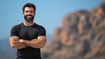 Strong man posing confidently outdoors against a scenic rocky backdrop on a sunny day photo