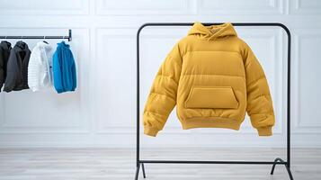 Stylish yellow puffer jacket displayed on a rack with other jackets in a modern showroom photo