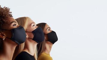 Three women wearing black masks looking upwards against a plain background, symbolizing unity and hope photo