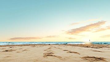 Tranquil beach scene at sunset with footprints in the sand and gentle waves lapping the shore photo