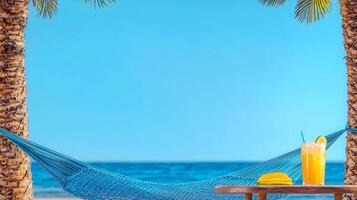 Tropical beach scene featuring a hammock between palm trees, with a refreshing drink and snack on a table photo