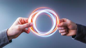 Two hands holding glowing energy rings, creating a dynamic visual effect against a gray background photo