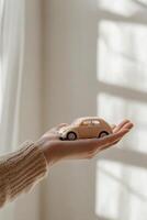 Two enormous yet gentle hands hold a tiny car, illuminated by warm golden light, symbolizing trust and care in a serene setting photo