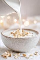 Milk cascades smoothly into a ceramic bowl filled with cereal, embodying freshness and comfort. The soft background highlights the inviting scene of a cozy breakfast photo