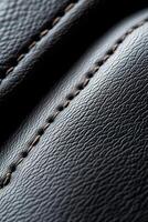 Close-up of a soft-focus black leather texture showcasing raised stitching in a subtle pattern, perfect for creating an elegant backdrop for branding messages photo