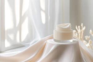 A glass jar of creamy skincare product is set on soft silk fabric, illuminated by gentle light, creating a serene and luxurious atmosphere that invites indulgence photo