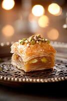 A warm piece of pistachio baklava sits elegantly on a decorative ceramic dish. The layers of phyllo pastry are glistening with honey, creating a tempting dessert experience photo
