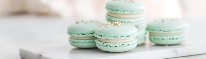 Softly stacked on a white marble tray, these pastel-green pistachio macarons feature a gentle dusting of crushed nuts and enjoy the embrace of natural light, creating an inviting dessert display photo