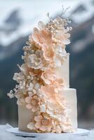 Softly toned vanilla or blush cake features cascading handcrafted sugar flowers and edible pearls, creating an exquisite centerpiece against a natural backdrop with mountains photo
