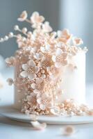 Delight in a soft vanilla cake featuring blush-toned handcrafted sugar flowers cascading elegantly down one side, accented with delicate edible pearls for a refined touch photo