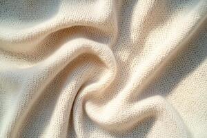 The composition showcases tightly woven beige knitted fabric featuring soft folds. Deep black shadows enhance the elegance and moodiness of the scene, adding depth to the texture photo