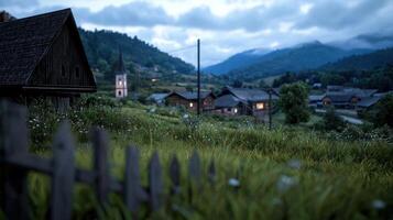 A small village with a church and a house with a wooden fence photo