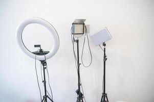 professional light sources against a white wall. three different sources for photo and shooting. the shape of the light sources is different. ring lamp, rectangular with and without curtains