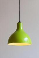 Bright lime green pendant lamp hanging from ceiling, showcasing modern design. smooth finish and arched shape add stylish touch to any interior space photo