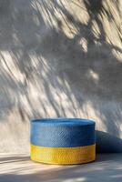 vibrant blue and yellow woven ottoman sits against textured wall, casting interesting shadows. This stylish piece adds pop of color to any modern space photo