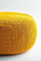 Bright yellow round woven pouf, perfect for outdoor or indoor decor. Its unique texture adds vibrant touch to any space, creating cheerful atmosphere photo