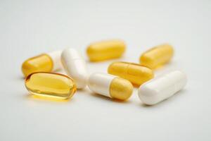 a group of pills on a white surface photo