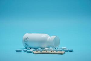 pills and a bottle of pills on a blue background photo