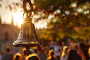 A large bell hanging from a tree in front of a crowd photo
