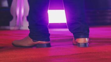 A person standing on a red carpet with their shoes on video