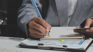 A business person is writing on a notebook with a pen video