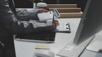A person in a suit is using a calculator on a desk video