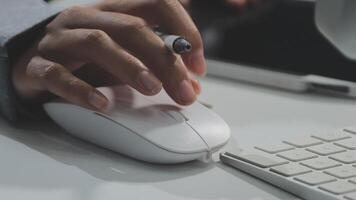 uma pessoa é usando uma rato para tipo em uma teclado video