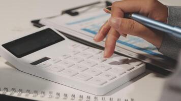 A person is using a calculator to calculate the numbers video