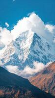 A Towering Peak Adorned with Snow Under a Dramatic Sky photo